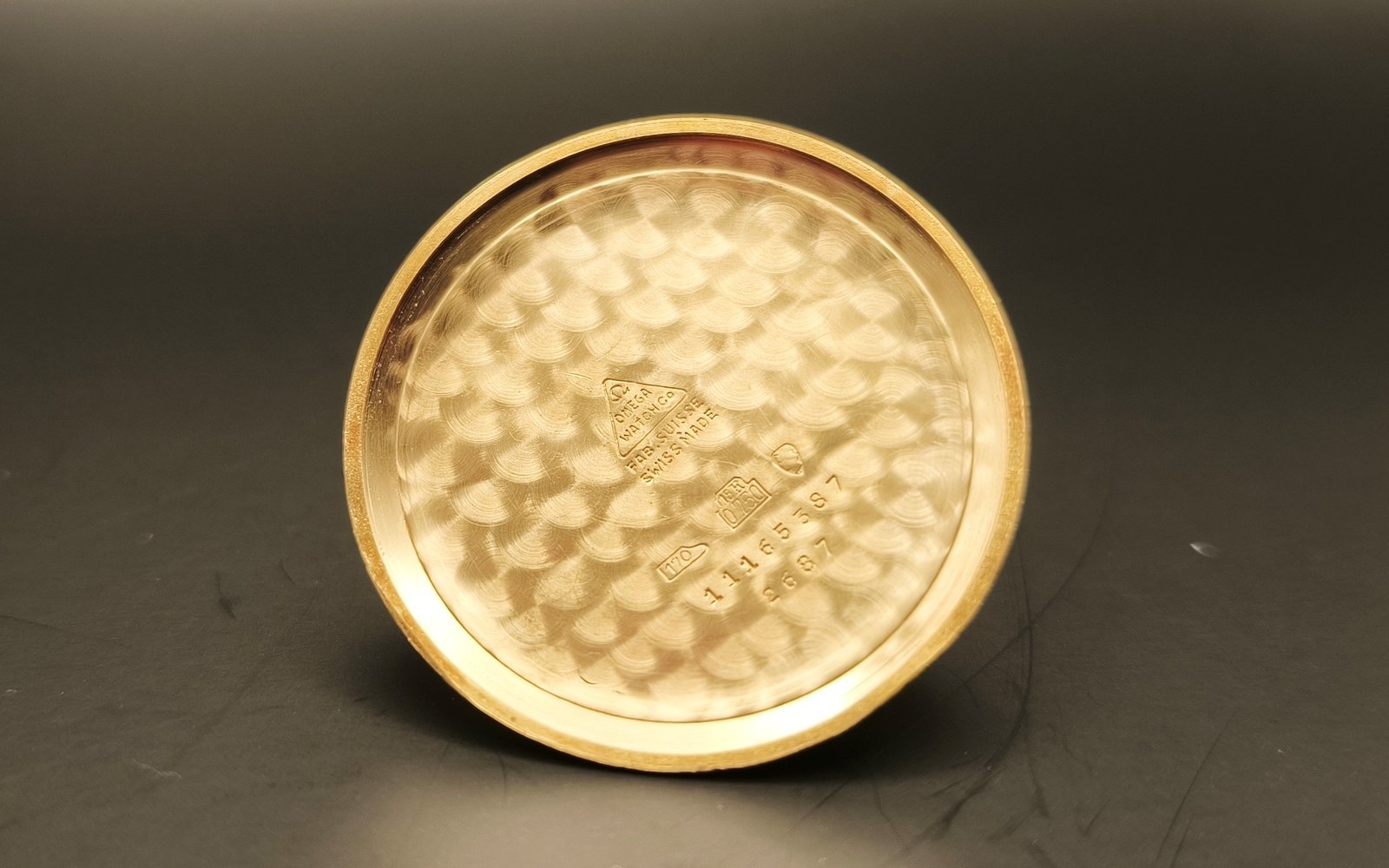 Vintage Omega 18K gold watch case back from 1952 showing hallmarks, reference number 2687, engraved details, gold patina, and vintage watch authentication marks from private watch collection