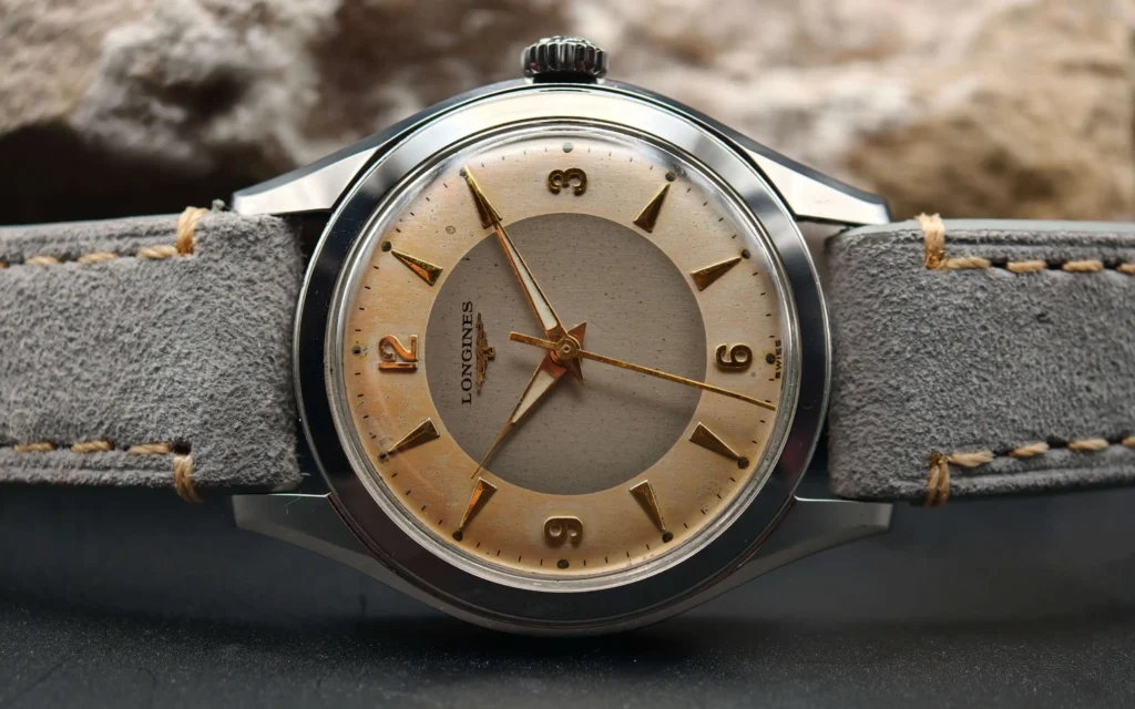 Vintage Longines stainless steel mechanical watch from 1954 showcasing classic watch design with handcrafted movement, aged two-tone dial with warm tropical patina, and timeless craftsmanship from private watch collection.