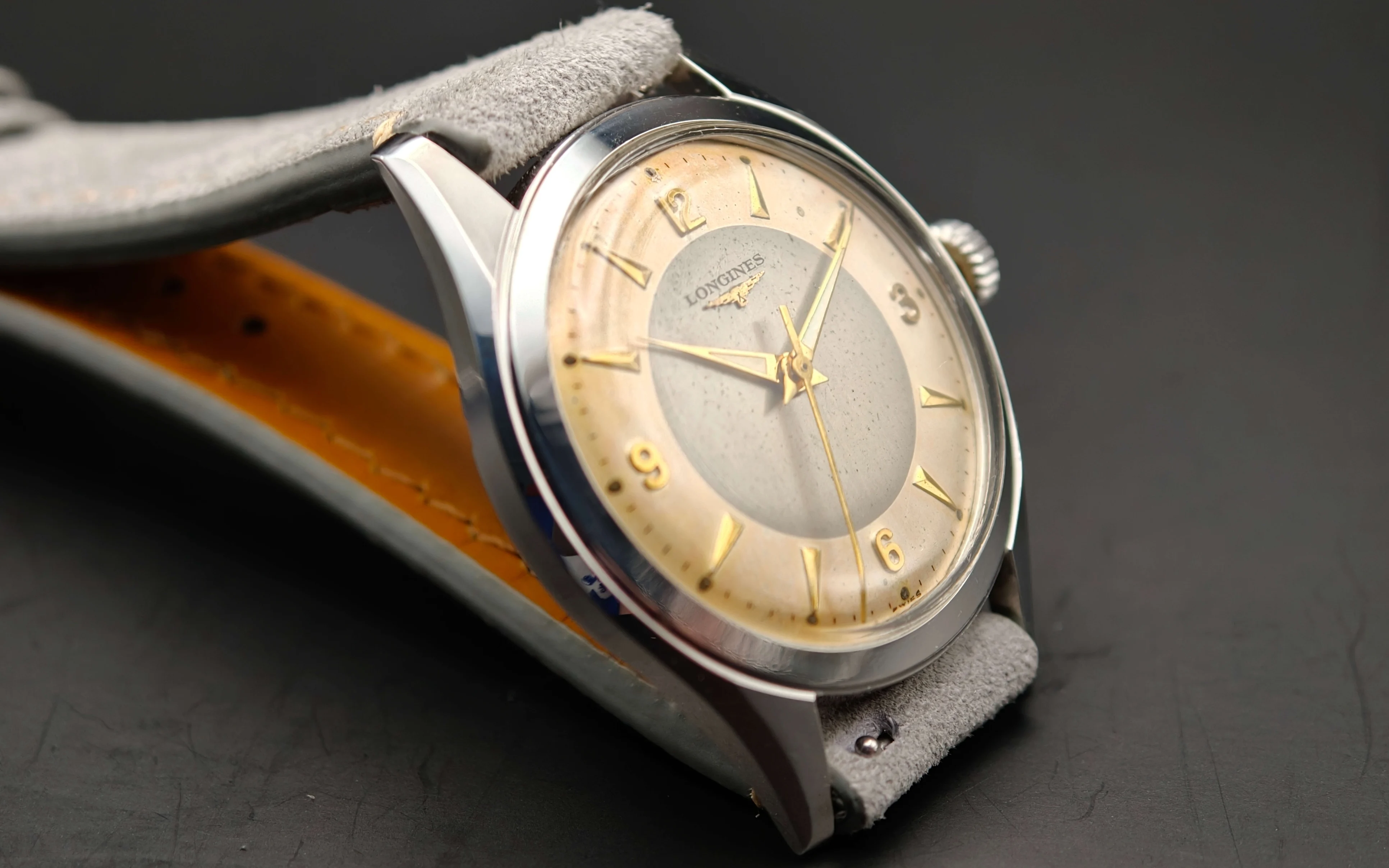 Vintage Longines stainless steel mechanical watch from 1954 showcasing classic watch design with handcrafted movement, aged two-tone dial with warm tropical patina, and timeless craftsmanship from private watch collection.